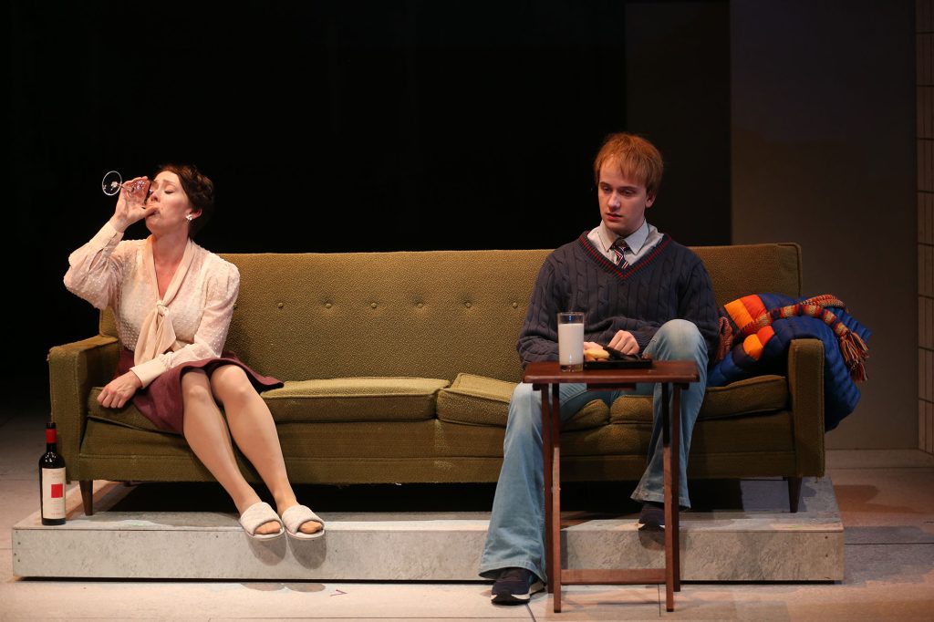 Oskar, played by Nathan Flesh, sits on the couch with his drunken mother, played by Kelly Mengelkoch, to face the consequences of his actions.