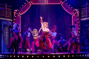 Cast of la Cage at the Carnegie in an enthusiastic dance number, in risque costume